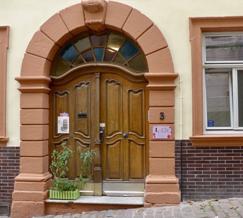 Carved wooden front door of Burgweg 3
