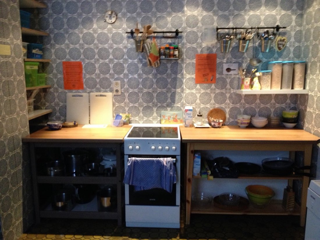 Self-catering kitchen with a stove, utensils and open shelves